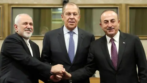 Reuters Russian Foreign Minister Sergei Lavrov (C), Turkish Foreign Minister Mevlut Cavusoglu (R) and Iranian Foreign Minister Mohammad Javad Zarif (L) shake hands as they attend a news conference after talks on forming a constitutional committee in Syria, at the United Nations in Geneva, Switzerland, on 18 December 2018
