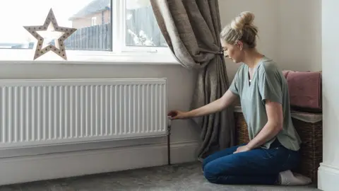 Getty Images Woman adjusting radiator valve