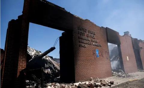 Getty Images A burned out post office in Minneapolis, Minnesota - buildings and businesses around the Twin Cities have been looted and destroyed in the fallout after the death of George Floyd while in police custody, 30 May 2020