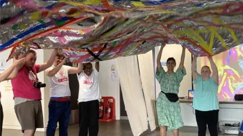 Charlotte Hollinshead  participants playing under a colourful banner