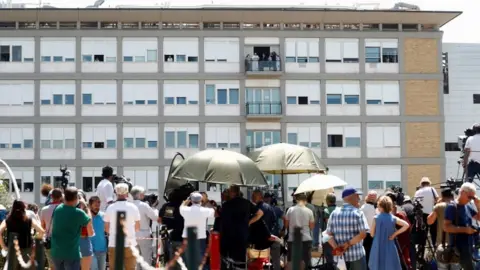 Reuters People attend an Angelus prayer led by Pope Francis from a balcony of the Gemelli hospital, as he recovers following scheduled surgery on his colon, in Rome, Italy, July 11, 2021