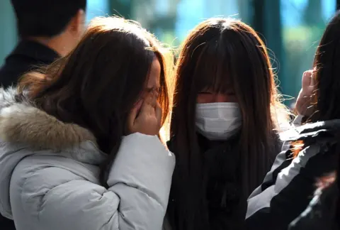 AFP/Getty Images Tearful fans gather to visit the mourning altar for Kim Jong-Hyun, a 27-year-old lead singer of the massively popular K-pop boyband SHINee, at a hospital in Seoul on 19 December 2017.