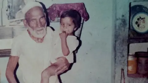 Mohd Ismail Mohammad Ali with one of his grandchildren