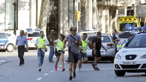 EPA Police and emergency workers set up a security perimeter near where a van was driven into pedestrians in Barcelona (17/08/17)