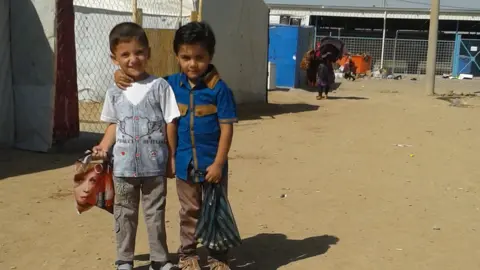 Khaled Muha Hassan with friend in the camp