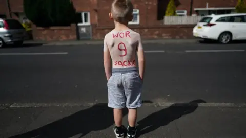 Getty Images A youngster has "Wor Jackie" and the number 9 painted on his back