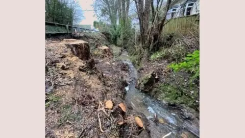 National Highways A picture of the A40 landslip site showing rocks and debris in the water