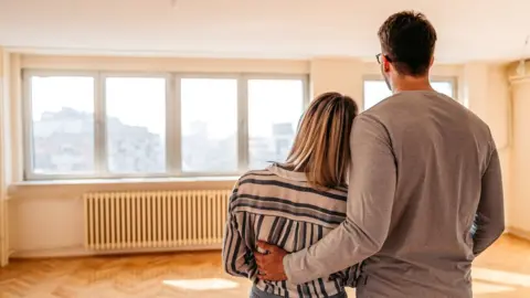 Getty Images Young couple looking at new home - stock image