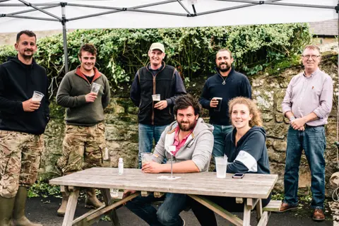 Joanne Coates/BBC A group of agricultural workers have gathered at The Chatton Arms Hotel. 4 July 2020