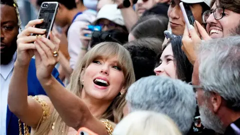 Getty Images Taylor Swift poses for a selfie with fans as she arrives to speak at the Toronto International Film Festival (TIFF) in Toronto, Ontario, Canada September 9, 2022