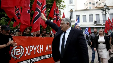 Getty Images Golden Dawn leader Nikolaos Michaloliakos salutes party supporters in 2017 (file pic)