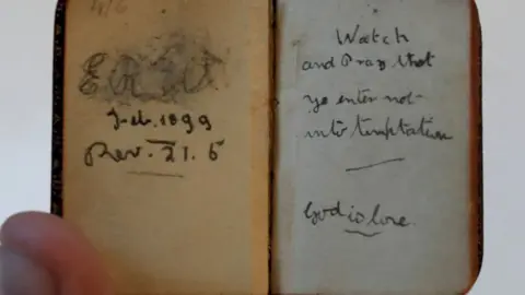 PA A staff member at Omega Auctions in Warrington holds a miniature bible, dated 1899 and with the initials ER (believed to stand for Eleanor Rigby) written inside