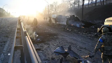 AFP Ukrainian service members are seen at the site of a fighting with Russian raiding group in the Ukrainian capital of Kyiv in the morning of February 26, 2022