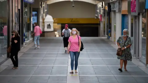 Getty Images A woman walking through Bridgend wearing a face mask