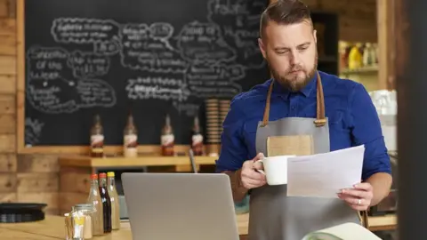 Getty Images Coffee shop owner analyses bills