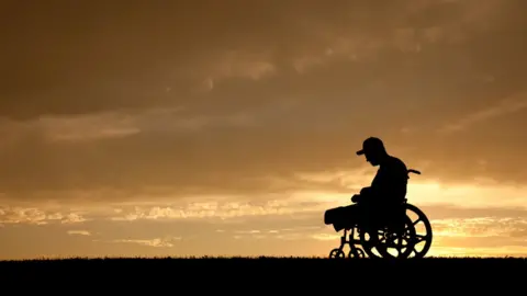 Getty Images A disabled man with his head bowed