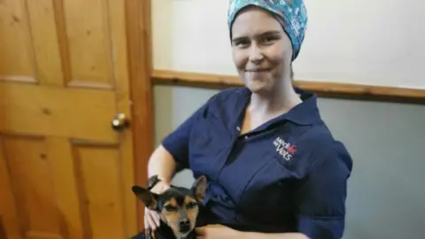 Dr Kiah Hann Dr Kiah Hann sitting in a wheelchair with a dog