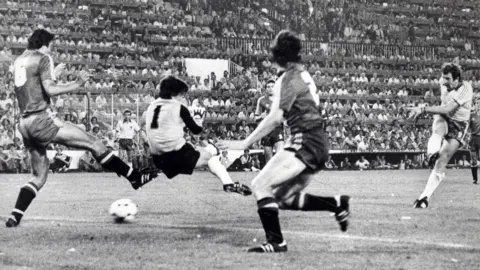 Pacemaker Gerry Armstrong blasts the ball into the net against Spain