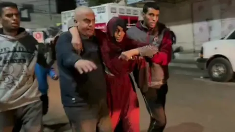 Injured woman being walked to hospital in Rafah