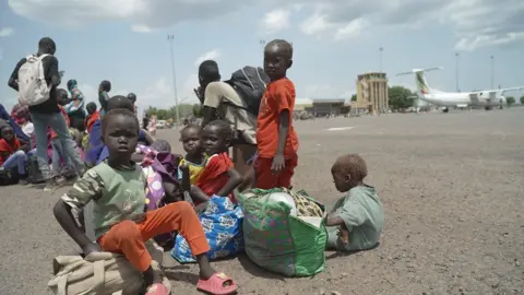 Hassan Lali/BBC Children on the runway at Paloich Airport