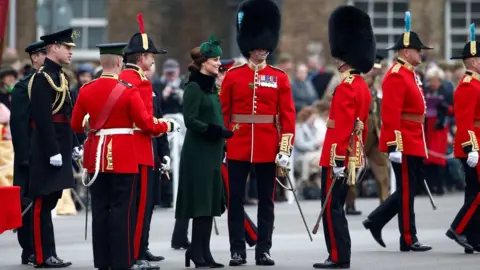 Reuters The Duchess presents shamrocks to officers as the Duke talks to others