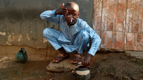 AFP A boy performs the ritual ablutions before praying at a mosque to celebrate Eid al-Fitr at a mosque in Kara Ibafo in Ogun State, on May 24, 2020.