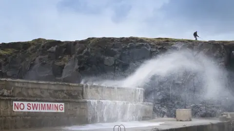 Charles McQuillan/Getty Images Wave crashing over sea wall in Portstewart