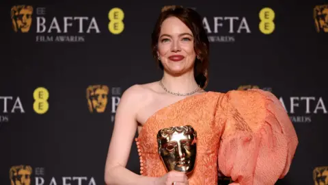 Emma Stone poses in the winners room at Baftas 2024