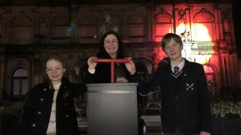 BBC/Naj Modak Family press button to launch colour and light project