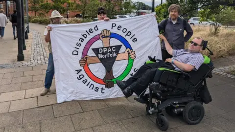 RICHARD HANCOCK/BBC Disability campaigners at Norwich railway station