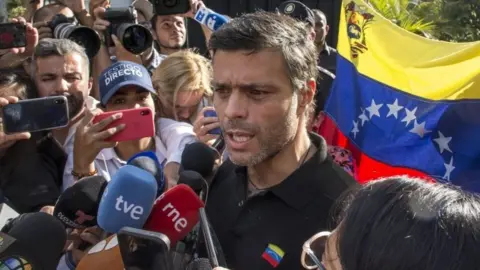 Getty Images Opposition figure Leopoldo López speaks to reporters at the gate of the Spanish embassy in Caracas, Venezuela. Photo: 2 May 2019