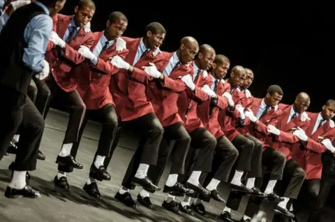 AFP A traditional Isicathamiya group performs at the Natal Playhouse Theatre in Durban on September 23, 2018, during an Isicathamiya competition. - The National Isicathamiya Competition held annually includes over 150 groups competing in the Isicathamiya style, an a capella choral singing style developed in South Africa by migrant Zulu communities.