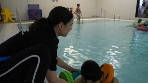 BBC Marta Hulin helps a young swimmer