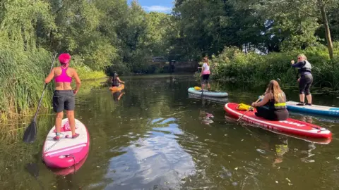 Melanie Miller Melanie Miller with friends she has made through paddleboarding