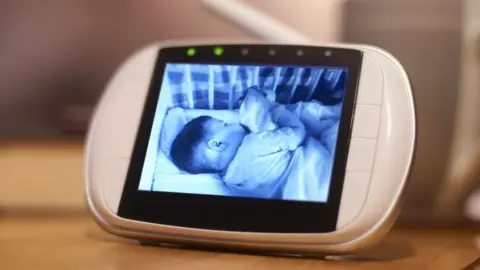 Getty Images A black and white video image of a baby sleeping is seen on a baby monitor