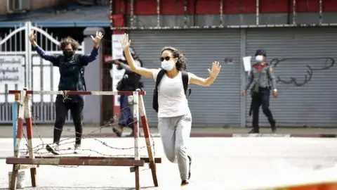 EPA People react as riot police fire tear gas during a protest against the military coup in Yangon, Myanmar