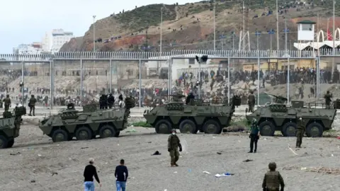 AFP Spanish armoured vehicles facing migrants at Ceuta border, 18 May 21