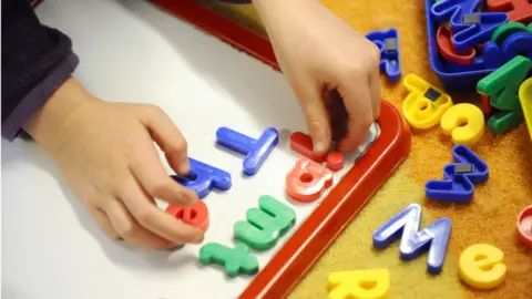 Dominic Lipinski Child playing with letters