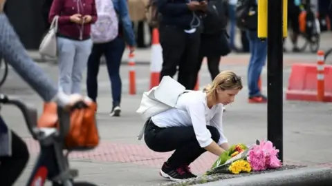 Getty Images Woman laying flowers