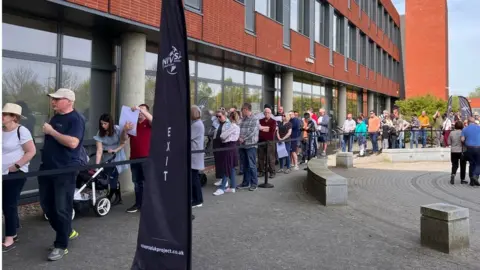 Holly Nicholls/BBC Queue of people outside Kimberley College