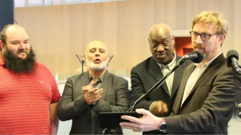 Tom Page Four men near microphones