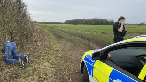 Norfolk Police A pair of mannequin legs kneeling in a hedge