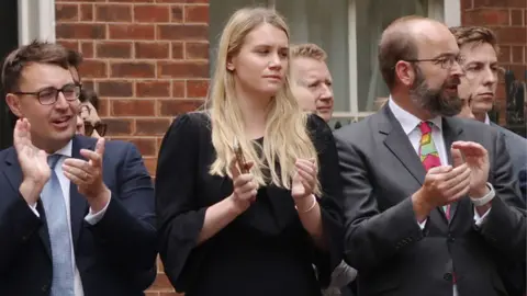Getty Images Charlotte Owen (centre) watches as Boris Johnson announces his resignation outside 10 Downing Street in July 2022