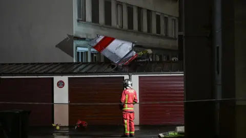 Getty Images The tail of the aircraft detached from the rest of the cabin and landed on the roof of a garage