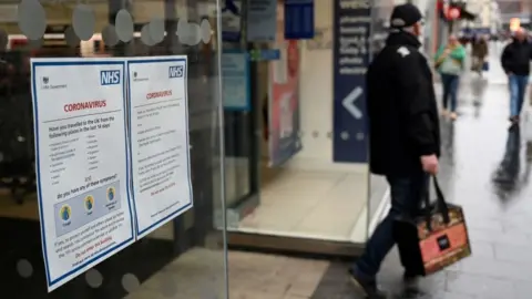 Getty Images Man leaving pharmacy with bag