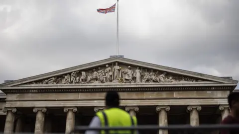 EPA A Union Jack waves on top the British Museum as a security staff manages the flow of visitors in London, Britain, 17 August 2023