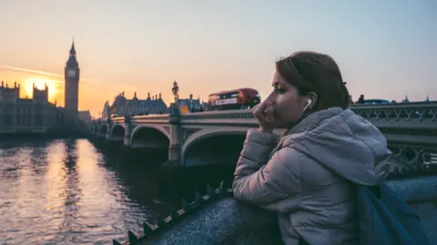 Getty Images Woman looking across the Thames at Parliament