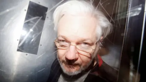 A Reuters Julian Assange arccal a kamerához közel hagyva elhagyja a londoni Westminster Courtot (archív fotó 2020-ból)
