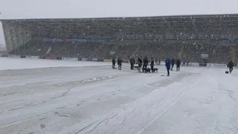 Newcastle Falcons Staff clear pitch in snow