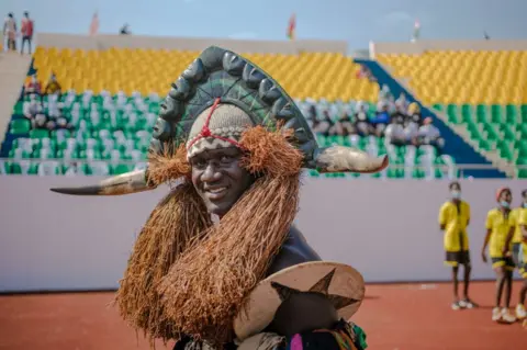 AFP A man in traditional dress parades in the September 24 Stadium prior the ceremony celebrating Independence Day in Bissau on November 16, 2021. - Independence Day 2021 was postponed by two months by decision of President Umaro Sissoco Embalo due to covid-19 and bad weather.